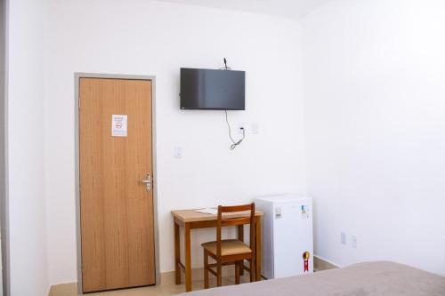 a room with a table and a door and a table and a chair at Pousada Salomão in Teixeira de Freitas