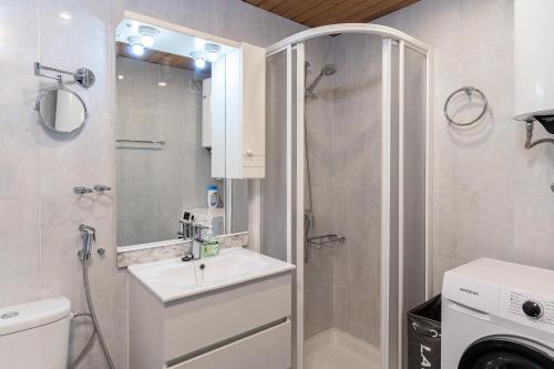 Un baño con lavabo y lavadora. en Azul Horizonte with a pool, en Benalmádena