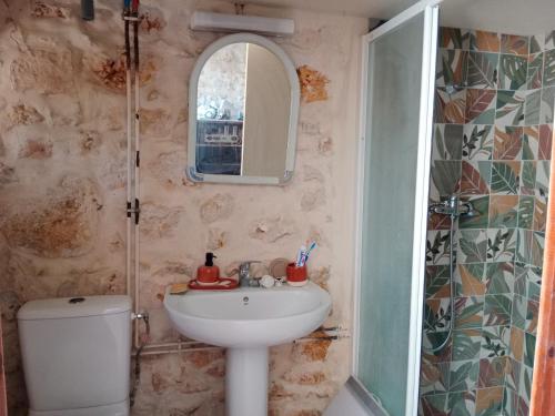 a bathroom with a sink and a toilet and a mirror at Chez Marguerite in Labastide-de-Virac