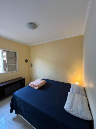 a bedroom with a blue bed with a blue blanket at Kasa Kaya in Araraquara