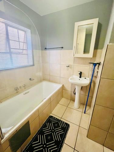 a bathroom with a bath tub and a sink at 2 Spacious bedroom apartment in Ellisras
