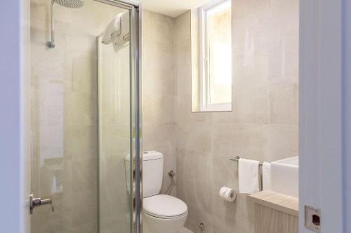 a bathroom with a toilet and a glass shower at Nightcap at Wintersun Hotel in Geraldton