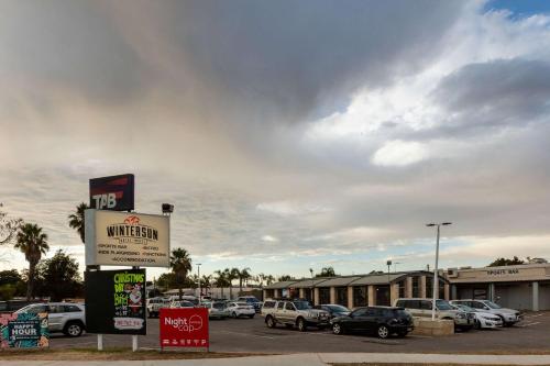 a parking lot with cars parked in front of a building at Nightcap at Wintersun Hotel in Geraldton