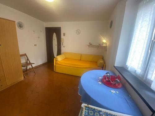 a living room with a yellow couch and a table at Monolocale antica fornace, un passo dal mare in Albissola Marina