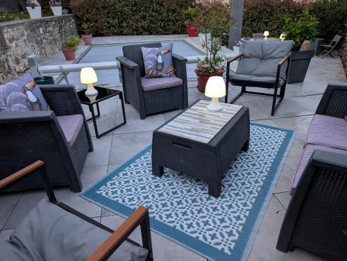 a patio with chairs and a table with lamps on it at La Maison d'Arlette - Maison d'Hôte et Gite au coeur de l'Isère à 10 mn de Voiron, capitale de la Chartreuse, et du Lac de Paladru in Saint-Blaise-du-Buis