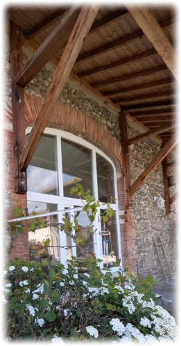 a window on the side of a brick building at La Maison d'Arlette - Maison d'Hôte et Gite au coeur de l'Isère à 10 mn de Voiron, capitale de la Chartreuse, et du Lac de Paladru in Saint-Blaise-du-Buis