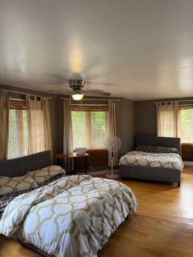 ein Schlafzimmer mit zwei Betten und einem Tisch und Fenstern in der Unterkunft Bear Lake Cottage in Mountain Grove