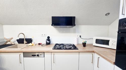a kitchen with a stove and a microwave at Apartments HAN 2 Sarajevo in Sarajevo