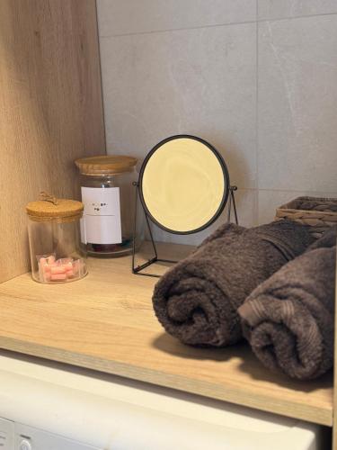 une étagère avec un miroir et des serviettes dessus dans l'établissement Appartement avec jardin privé à 10 min de Disneyland, idéal familles, à Couilly-Pont-aux-Dames