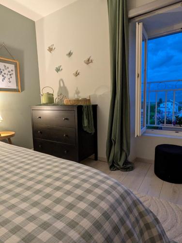 a bedroom with a bed and a window with birds on the wall at La Maison d'Arlette - Maison d'Hôte et Gite au coeur de l'Isère à 10 mn de Voiron, capitale de la Chartreuse, et du Lac de Paladru in Saint-Blaise-du-Buis
