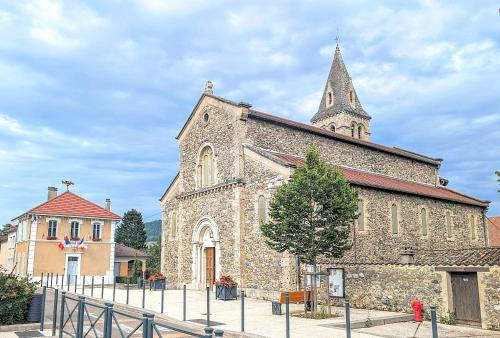 an old stone church with a steeple on top of it at La Maison d'Arlette - Maison d'Hôte et Gite au coeur de l'Isère à 10 mn de Voiron, capitale de la Chartreuse, et du Lac de Paladru in Saint-Blaise-du-Buis