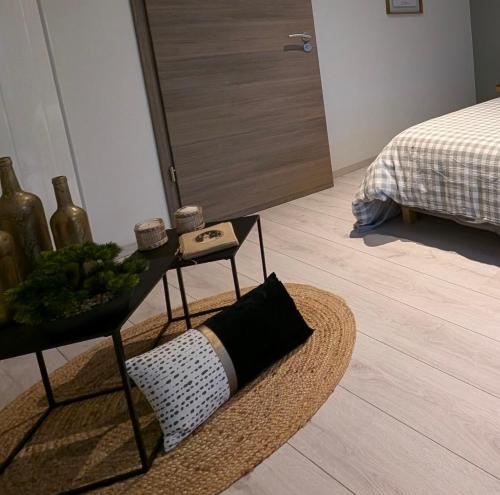 a living room with a table and a bed at La Maison d'Arlette - Maison d'Hôte et Gite au coeur de l'Isère à 10 mn de Voiron, capitale de la Chartreuse, et du Lac de Paladru in Saint-Blaise-du-Buis