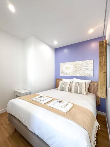 - une chambre avec un grand lit blanc et un mur bleu dans l'établissement Villa des Camelias, à Le Pré-Saint-Gervais