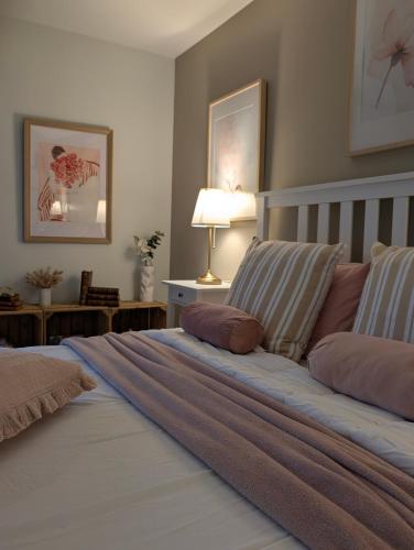 a bedroom with a large bed with two pillows at La Maison d'Arlette - Maison d'Hôte et Gite au coeur de l'Isère à 10 mn de Voiron, capitale de la Chartreuse, et du Lac de Paladru in Saint-Blaise-du-Buis