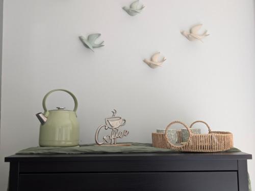 a table with a tea kettle and baskets on it at La Maison d'Arlette - Maison d'Hôte et Gite au coeur de l'Isère à 10 mn de Voiron, capitale de la Chartreuse, et du Lac de Paladru in Saint-Blaise-du-Buis