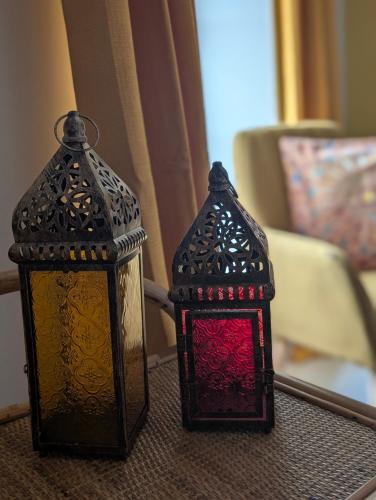 two glass lanterns sitting on top of a table at La Maison d'Arlette - Maison d'Hôte et Gite au coeur de l'Isère à 10 mn de Voiron, capitale de la Chartreuse, et du Lac de Paladru in Saint-Blaise-du-Buis