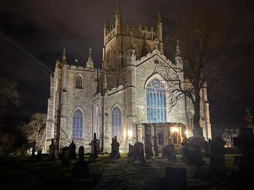 an old church at night with a bunch of graves at 4B Millhill Street in Dunfermline