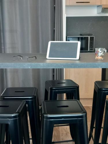 a table with stools and a laptop on a counter at T3 Meublé 6 Couchages in Monein