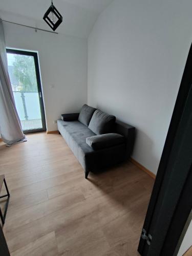 a living room with a couch and a window at Apartamenty Słonecznikowa in Tupadły