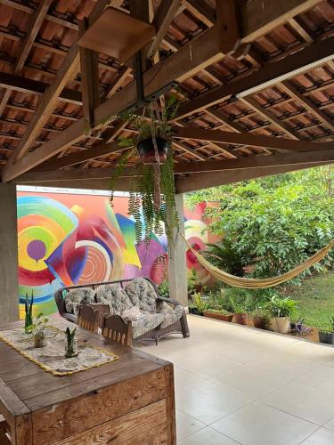 a patio with a couch and a painting on a wall at Kasa Kaya in Araraquara