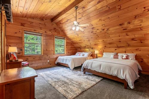 twee bedden in een blokhut slaapkamer met houten wanden bij Fantastic Mr. Fox By Avada Properties in Pigeon Forge