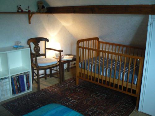 - une chambre avec 2 lits superposés et une chaise dans l'établissement Le petit chemin, à Bougival