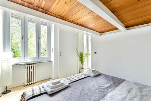 Un dormitorio con una cama grande con techo de madera. en Blanc72, en Turín