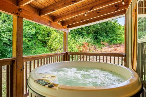 einen Whirlpool auf einer abgeschirmten Veranda mit einem Holzdach in der Unterkunft Duck Duck Moose By Avada Properties in Sevierville