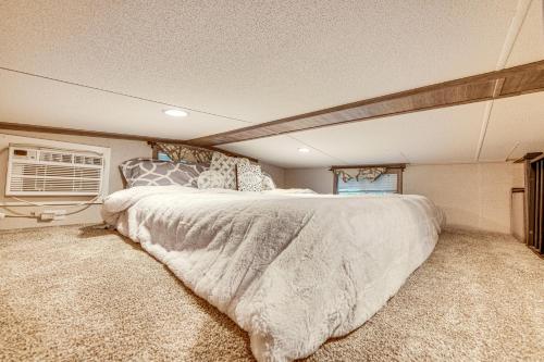 a bedroom with a large bed and a window at Walk to Lake Beaches Cabin with Patio in Belmont! in Belmont