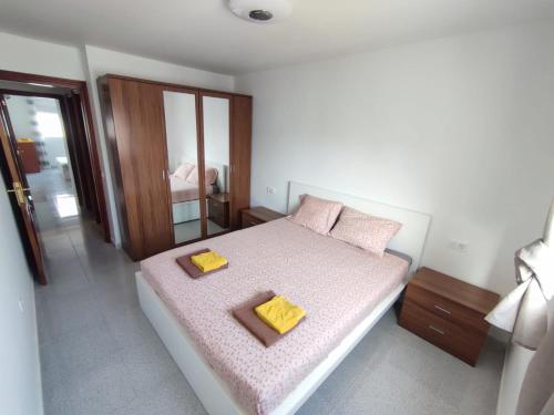 a bedroom with a bed with two yellow pillows on it at Casa Zenn in Puerto del Rosario