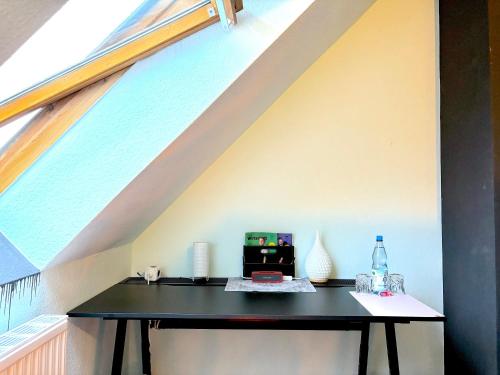 a black table in a loft with a window at Ruhe Oase Steinhöfel - Balkon, Naturblick, Design-Maisonette-Apartment - nahe Fürstenwalde-Spree in Steinhöfel