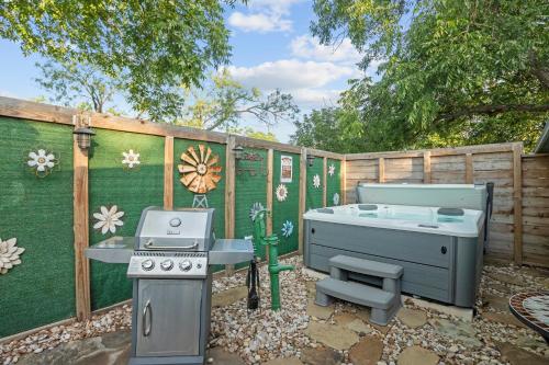 a backyard with a grill and a hot tub at 1929 Wash House in Fredericksburg