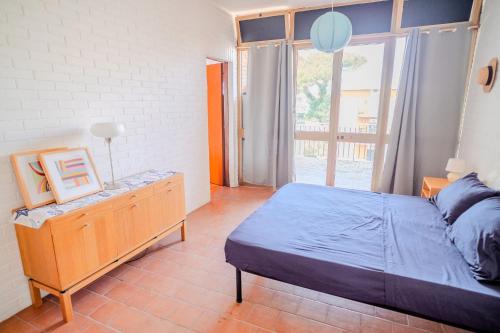 a bedroom with a bed and a dresser and a window at San Giacomo Sweet Home in Nettuno