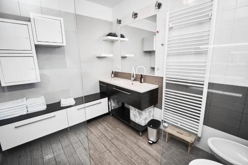 een witte badkamer met een wastafel en een spiegel bij Matic Murgle Atrium Apartment in Ljubljana