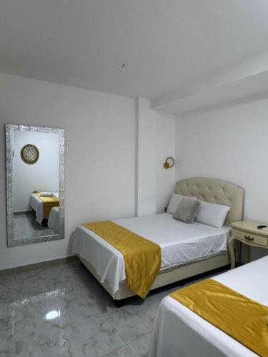 a hotel room with two beds and a mirror at Hotel The Royalty Inn in Guayaquil