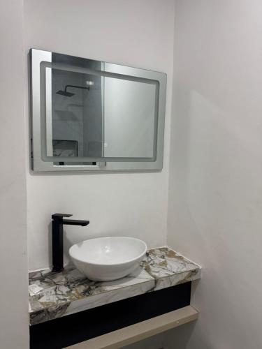 a bathroom with a white sink and a mirror at Hotel The Royalty Inn in Guayaquil