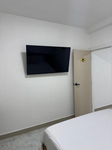 a room with a flat screen tv on a wall at Hotel The Royalty Inn in Guayaquil