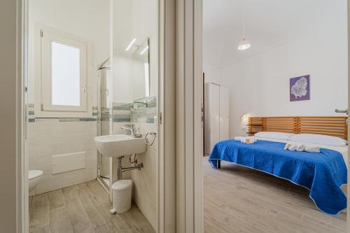 a bathroom with a bed and a sink and a shower at Meucci Favignana Apartments in Favignana