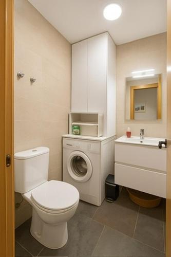 a bathroom with a toilet and a sink and a washing machine at Vivienda privilegiada cerca del mar, Cabo de Palos in Cabo de Palos