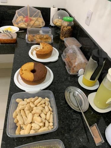 a counter topped with plates of food and drinks at Pousada Salomão in Teixeira de Freitas