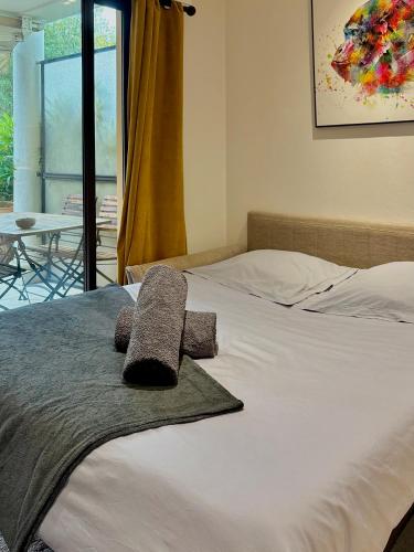 une chambre avec un lit avec deux oreillers dessus dans l'établissement Charmant studio - AC - Piscine - Terrasse - Parking, à Mandelieu-la-Napoule