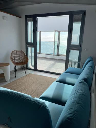 a living room with a couch and a view of the ocean at LAR Tamaduste in Tamaduste