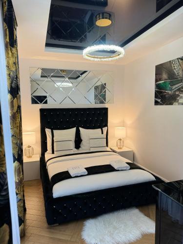 a bedroom with a black bed with white pillows at Aquarius Residence apartament 203 in Boszkowo