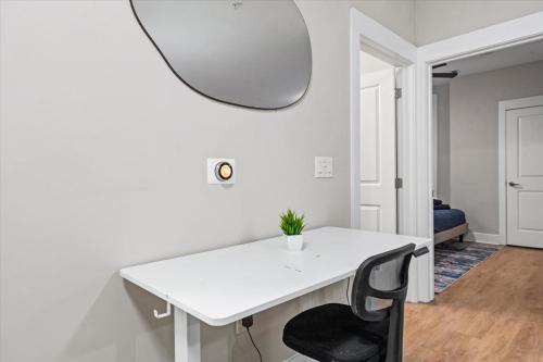 a white table with a black chair and a mirror at Luxurious King 3BR Suite in North Raleigh! in Raleigh