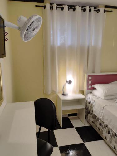 a bedroom with a bed and a desk and a chair at Kzazendf Cama&Cafe Hospedagem Familiar in Brasilia
