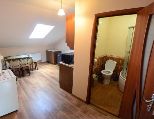 a bathroom with a toilet and a dining room at City Hostel in Kolomiya