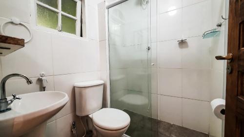 a bathroom with a shower and a toilet and a sink at Chalés Ubatuba do Alto in Ubatuba