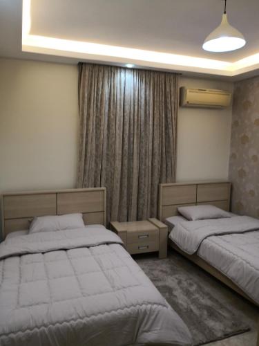 a bedroom with two beds and a window at Alhejaz Luxurious Apartment in Cairo