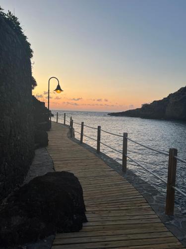 a wooden pier with a street light and the ocean at LAR Tamaduste in Tamaduste