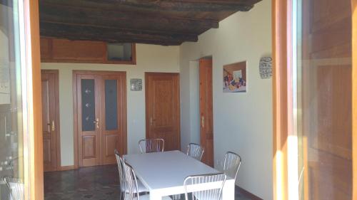 a dining room with a white table and chairs at A casa di Anna - vista mare nel centro storico in Amantea